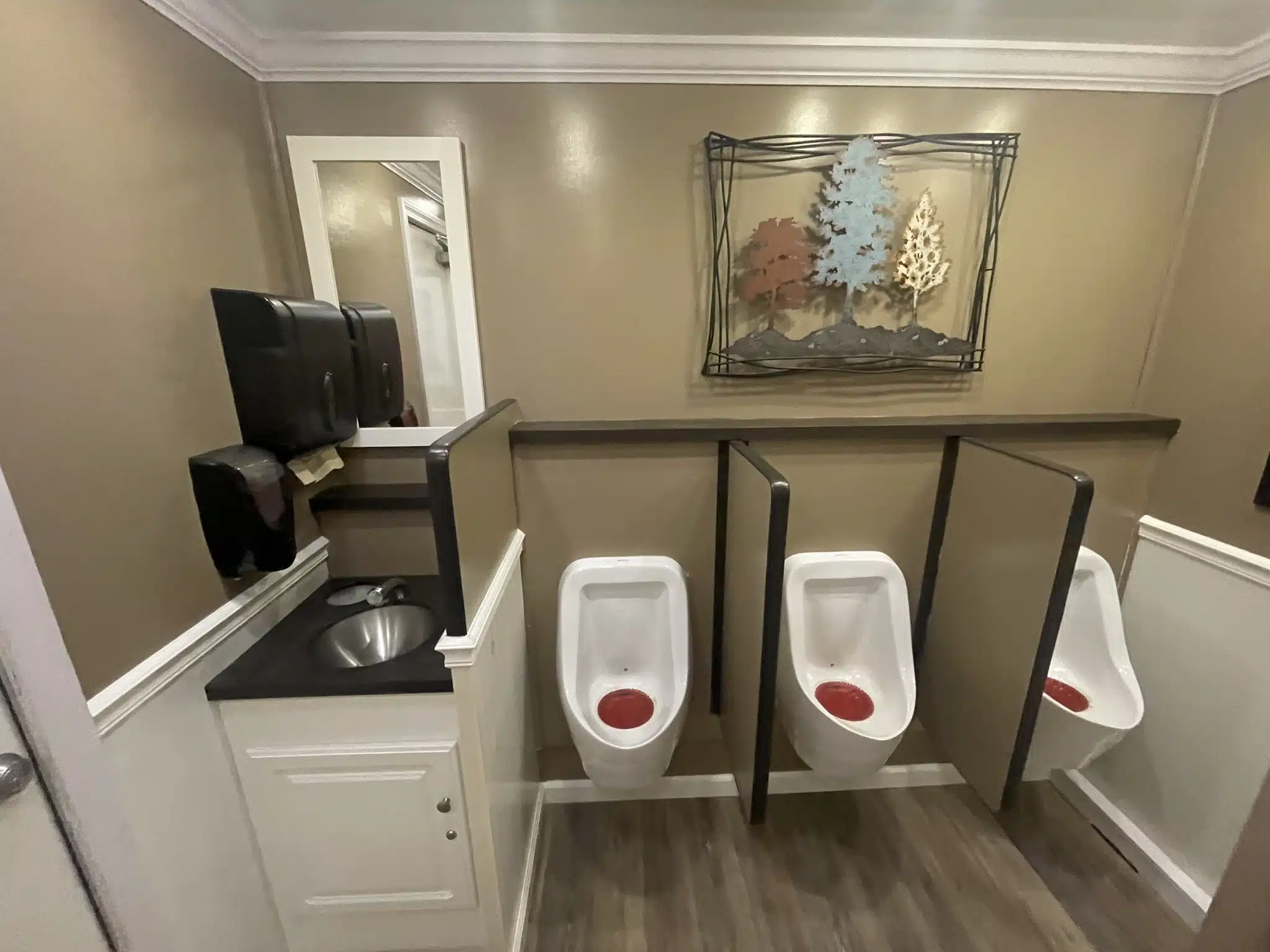 a bathroom with two urinals and a sink.